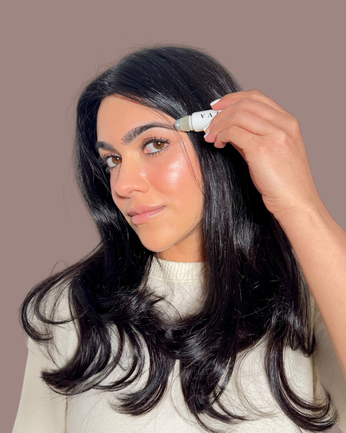 applying halva beauty nourishing brow oil with roller ball for fuller brows