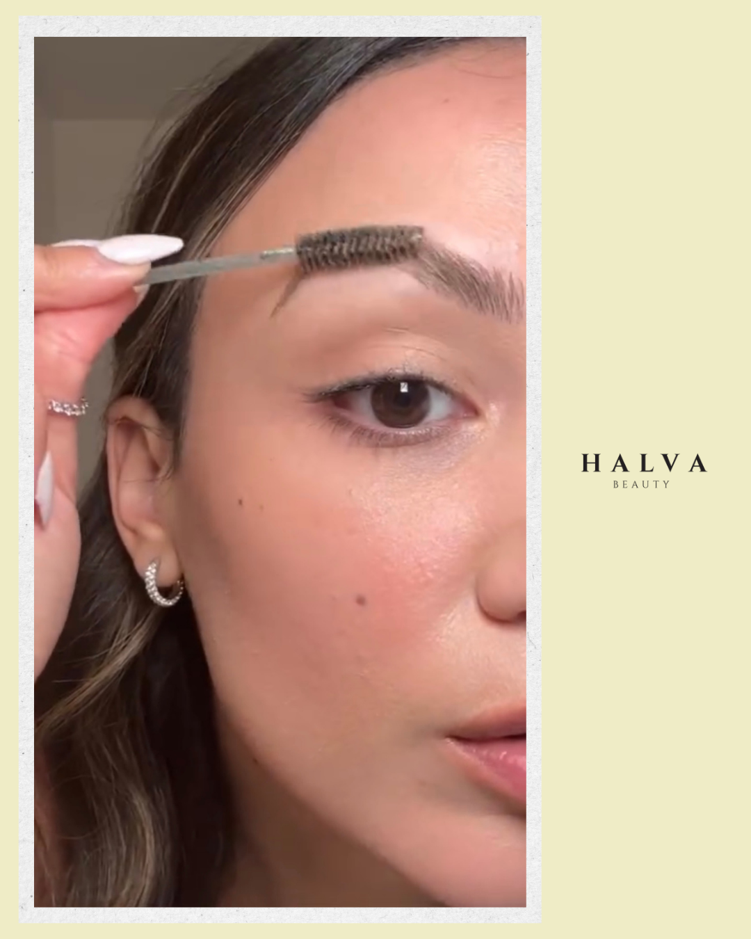 woman applying halva beauty nourishing brow oil with spoolie brush to natural eyebrows, close-up of fuller brow care routine.