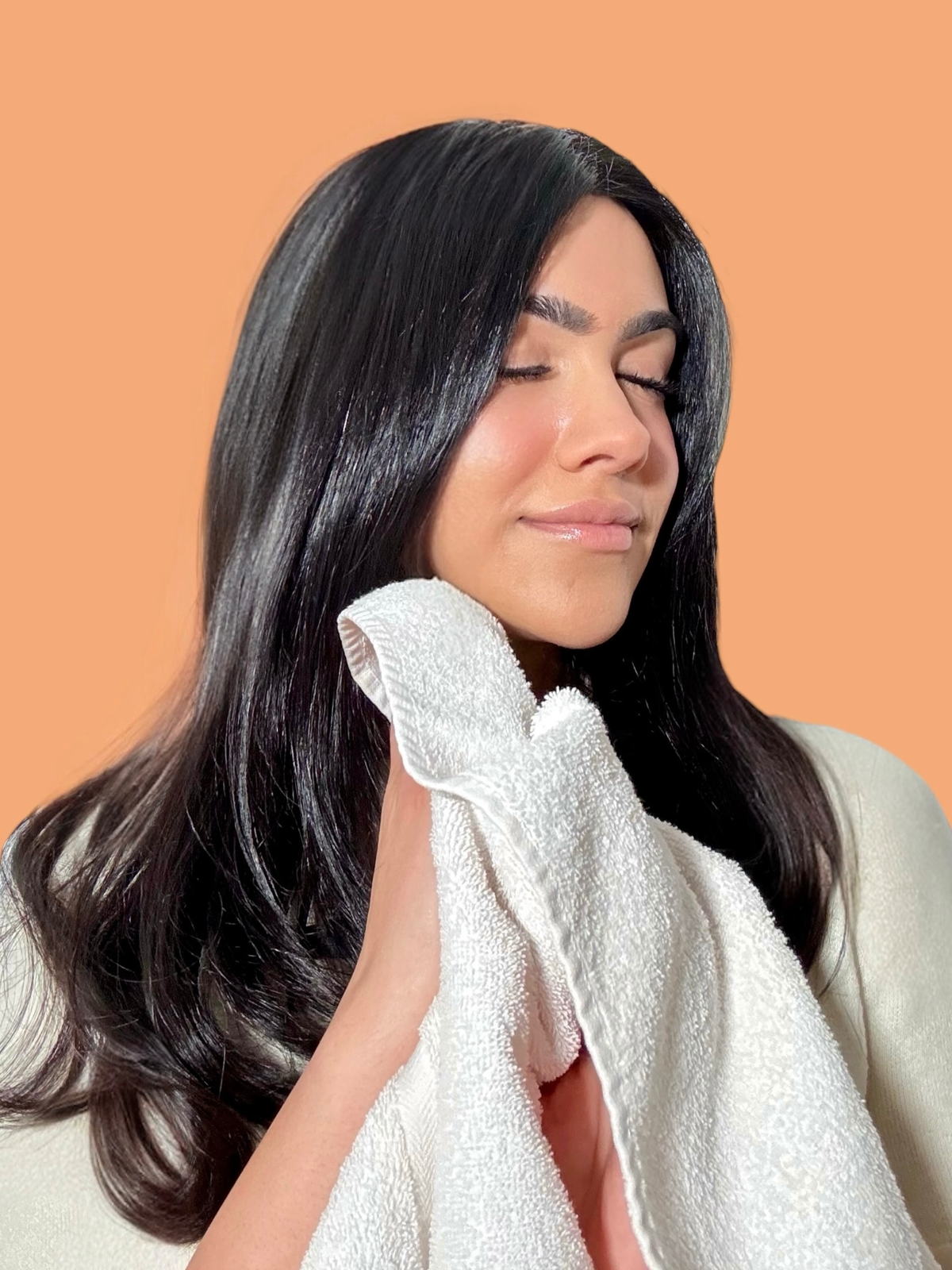 halva beauty founder kiren ajrawat gently rinsing off brow oil with a soft cloth as the final step of her brow routine before bed or makeup