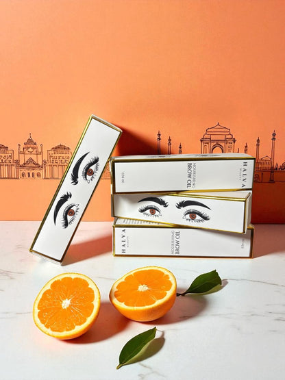 halva beauty nourishing brow oil boxes with indian architecture backdrop and oranges
