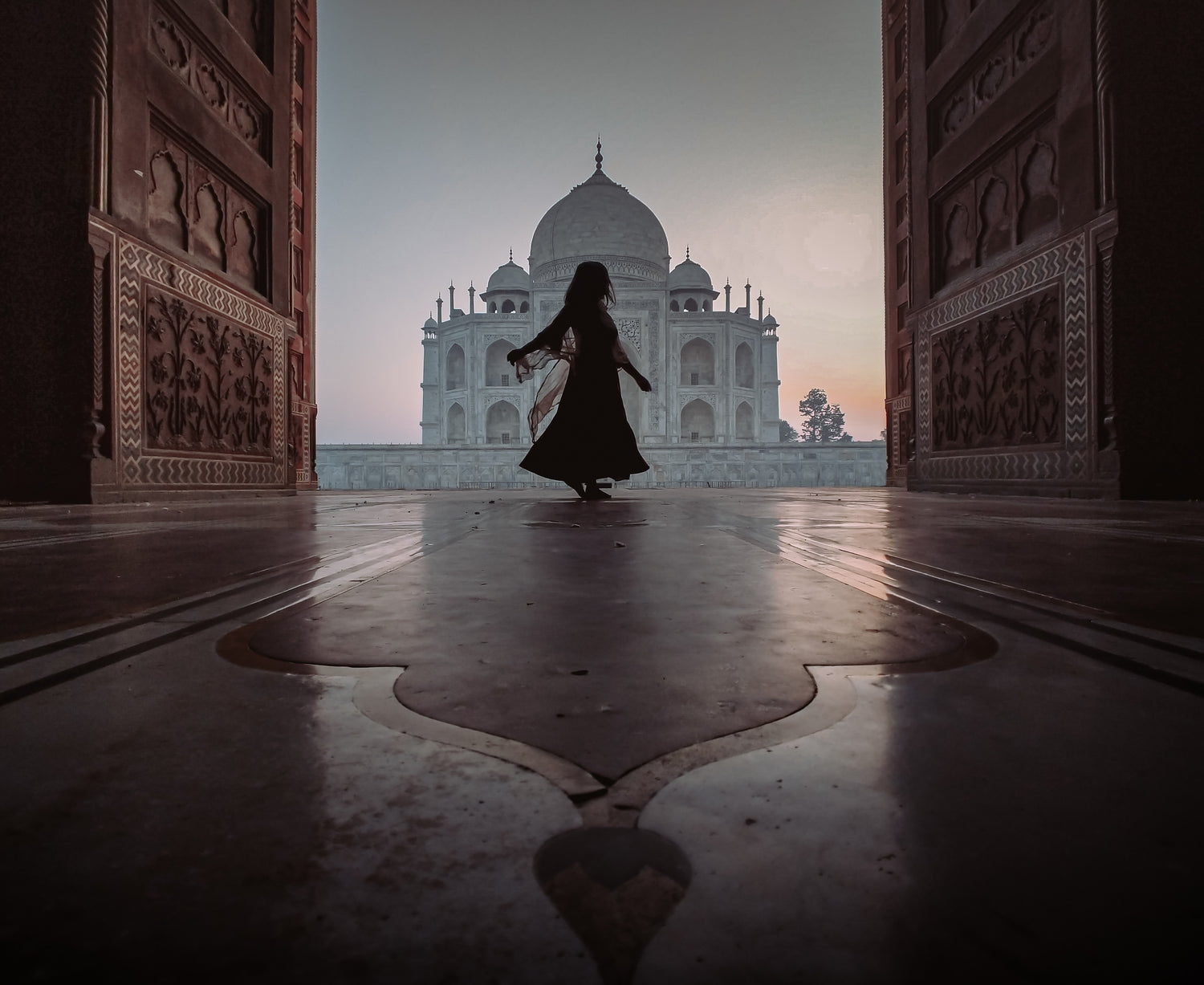 woman dancing in front of the taj mahal